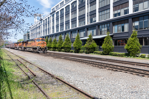 BNSF freight train passing office buildings from Alaskan Way, Seattle, USA