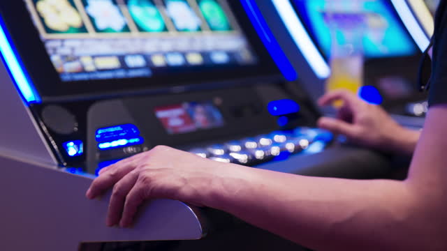 hand close up Exited Young Asian cheerful male man enjoy playing on a slot machine at the casino and winning, celebrate man win slot machine