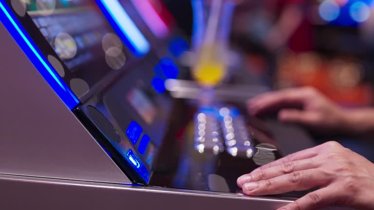 hand close up Exited Young Asian cheerful male man enjoy playing on a slot machine at the casino and winning, celebrate man win slot machine