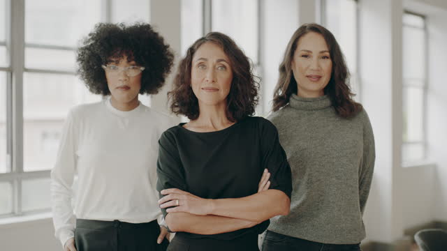 Three businesswomen are standing and looking into the camera. Stock video