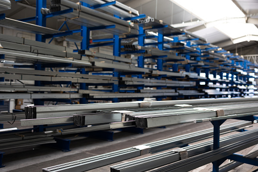 Stock of raw metal materials in a facatory hall (shallow DOF; color toned image)