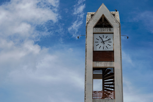 Clock tower with blue sky and white clouds.