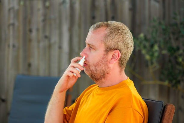 istock Man suffering from hay fever allergy using nasal spray 1500062549