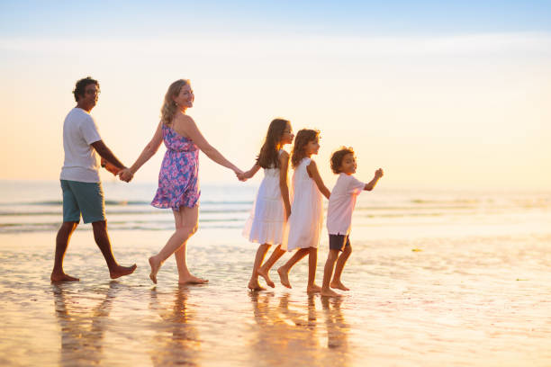 istock Family walking on tropical beach at sunset 1500065902