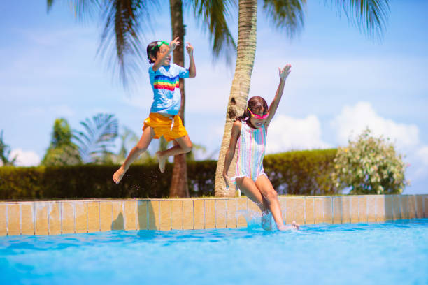 istock Kids jump into swimming pool. Summer water fun. 1500066635