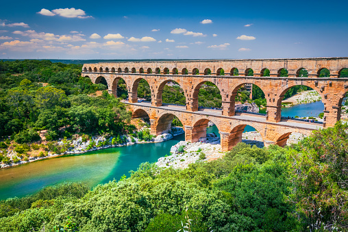 Pont du Gard, France. Ancient three-tiered aqueduct, built in Roman Empire times on the river Gardon. Provence, tourist destination, summer sunny day landscape.