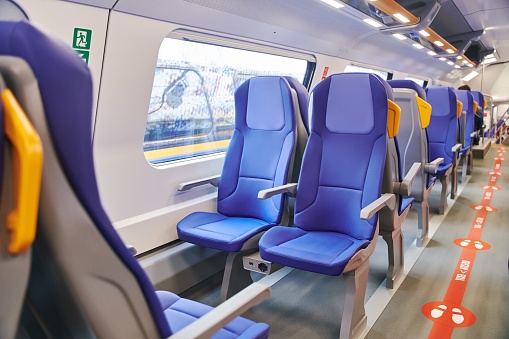 Modern high speed train interior with empty blue seats. High quality photo