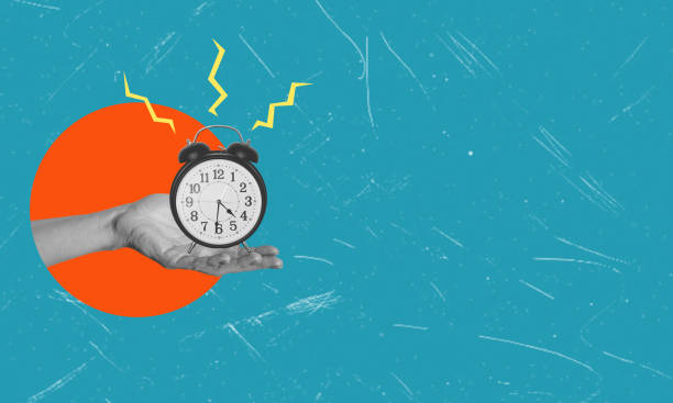 Human hand-holding alarm clock on a blue background, concept idea.