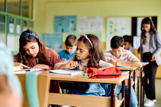 istock Hispanic schoolgirl learning while attending a class in the classroom. 1500076399