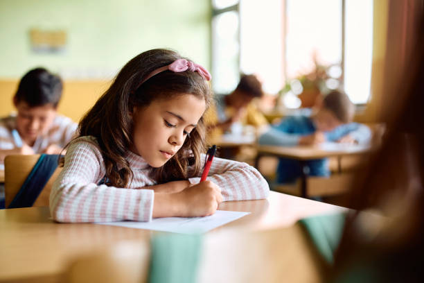 istock Hispanic schoolgirl writing an exam during a class in the classroom. 1500076413