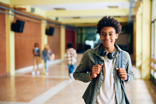 feliz estudiante negro en la escuela secundaria mirando a la cámara. - niño de escuela secundaria fotografías e imágenes de stock