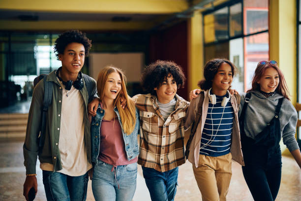 istock Cheerful high school students walking embraced through the hallway. 1500076705