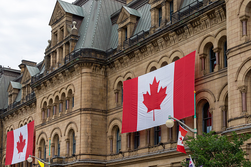 Canada, Ottawa - July 1, 2022: Canada Day. Canadian flags on building. Office of the Prime Minister and Privy Council.