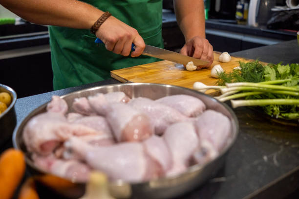 a blond man with a beard and a green apron prepares dinner in his home kitchen. - routine foods and drinks clothing household equipment imagens e fotografias de stock