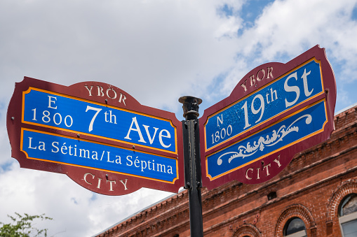 Ybor City, Tampa, FL, US-April 23, 2023:  Street sign on the corner of 19th and 7th Avenue in the historic neighborhood of Ybor City first settled by Cuban immigrants.