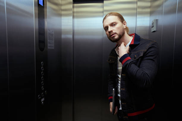 istock Guy with the laptop is in the passenger elevator 1500084713