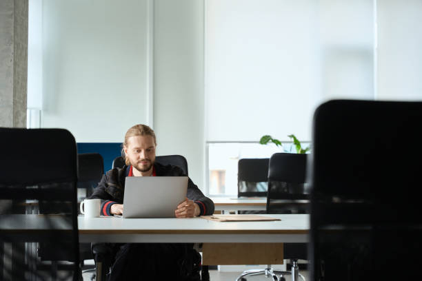 istock Guy with a laptop sits at a large conference table 1500084782