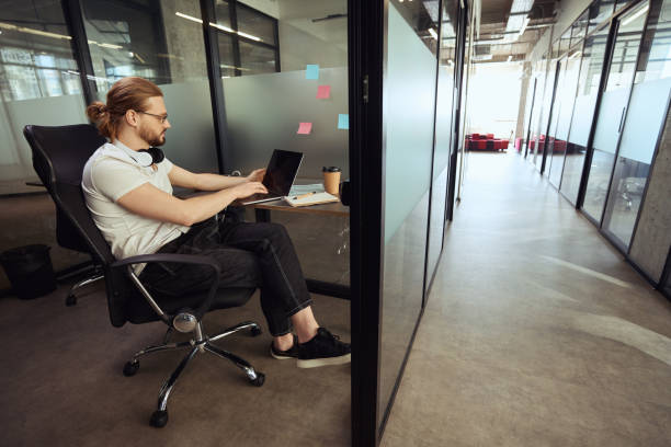 istock Young employee with a headset sits in comfortable office block 1500084848