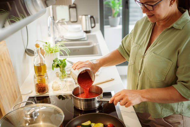 istock Woman in kitchen preparing tomato sauce 1500086801