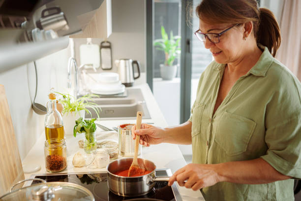 istock Woman stirs boiling tomato sauce 1500086828