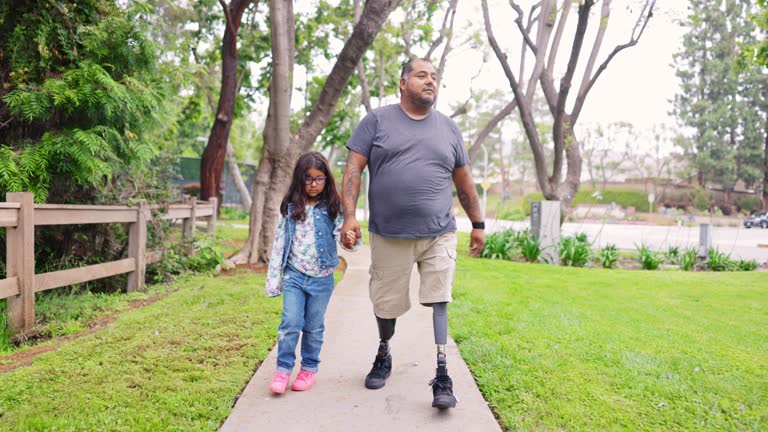 Disabled Hispanic Veteran Walking a Path with his daughter