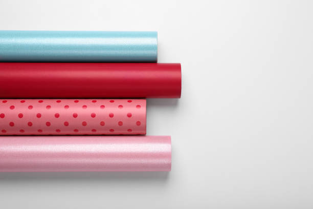 Rolls of colorful wrapping papers on white background, top view. Space for text
