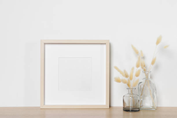 istock Empty photo frame and vases with dry decorative spikes on wooden table. Mockup for design 1500091308