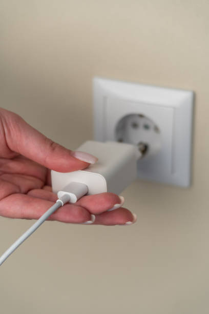 istock Female hand plugging phone charger, wire, charger 1500095126