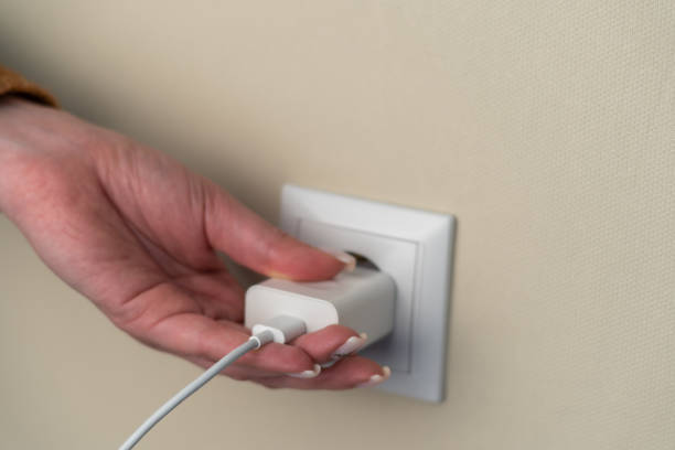 istock Female hand plugging phone charger, wire, charger 1500095129
