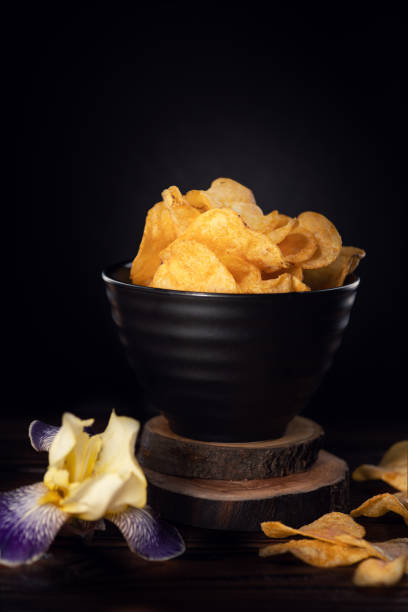 Crispy ripple potato chips in black bowl. stock photo