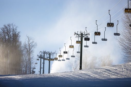 This stock photo features a scenic winter scene with multiple ski lifts in the background and skiers at the bottom of the incline