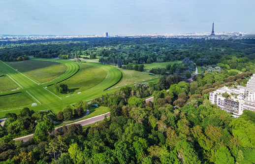 Aerial View on Boulogne forest and part of hippodrome in Paris . Eiffel tower in distance. Beauty of nature in May. Photo from Edmon de Rothschild Garden