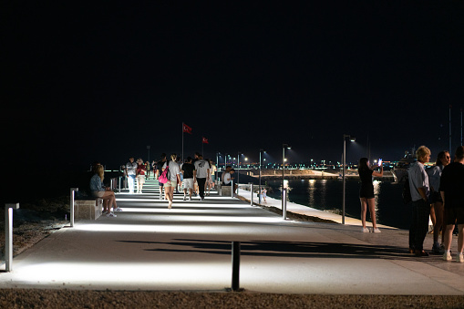Side,Manavgat ,Turkey : June 6 2023 People taking an evening stroll in Side harbor