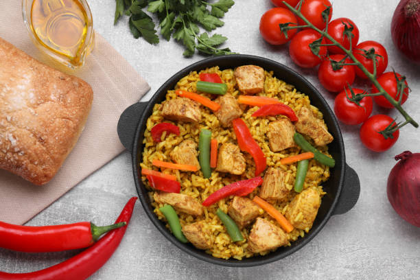 istock Delicious rice and chicken served with vegetables on light grey table, flat lay 1500098216