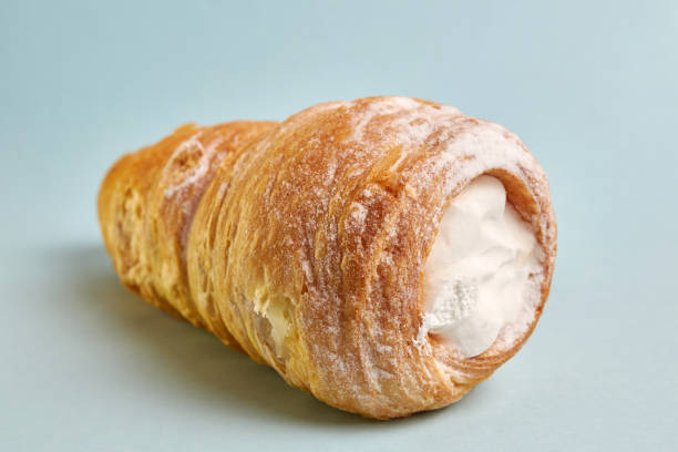 istock Pipe of puff pastry with meringue on a blue background. 1500098454