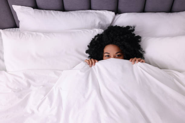 istock Young woman lying in soft bed at home, above view 1500099341