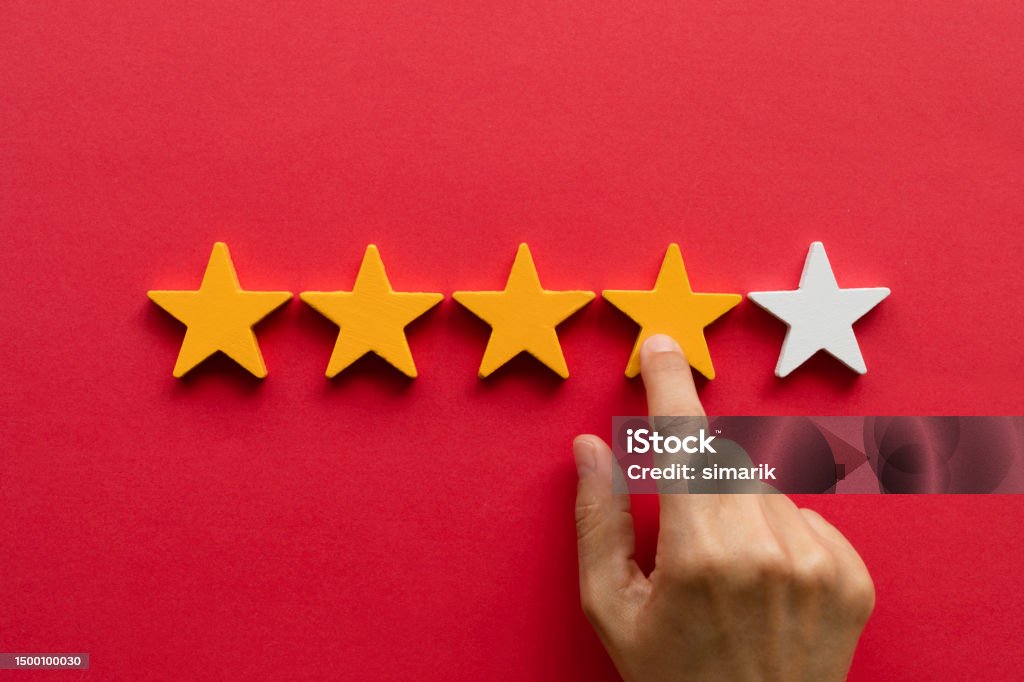 Five star rating feedback Five star rating feedback. Hand is pointing at fourth star shape in front of red background. Giving score point to review the service Five Objects Stock Photo