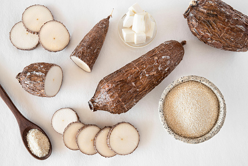 Cassava root and flour on a white background