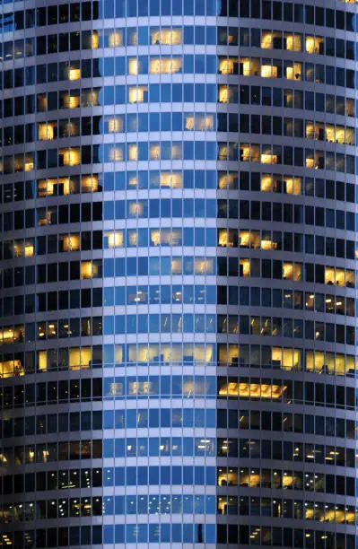 Photo of Skyscraper façade at night - pattern with some offices lit - backgrounds