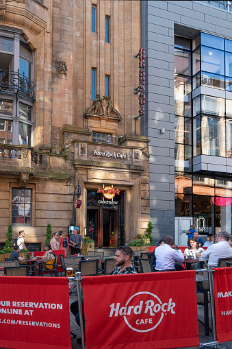 15 June 2023 - Glasgow, Scotland, UK:  Customers sitting on the pavement terrace outside the Hard Rock Cafe in Glasgow, Scotland. The cafe is located in the former Athaneum Theatre (1983), a Grade A listed building. The Hard Rock Cafe is headquartered in Florida, USA