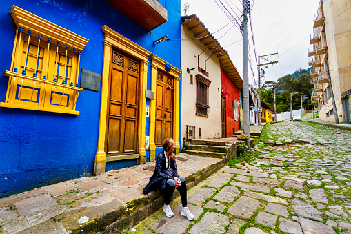 Tourist woman sitting on a street in La Candelaria, Bogota, Colombia
