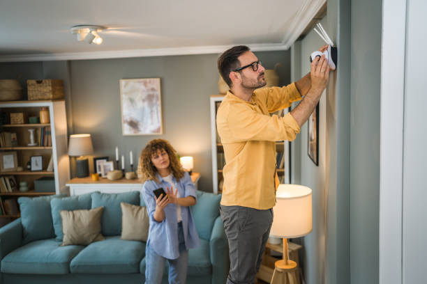 Couple at home connect and install cctv security surveillance camera Couple adult caucasian man and woman at home connecting setup and install cctv security video surveillance camera monitoring system indoor security camera stock pictures, royalty-free photos & images