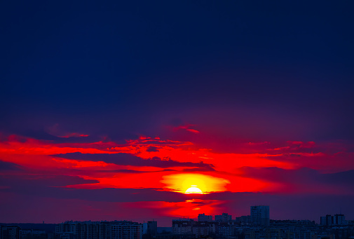 Beautiful sunset in the city with red sky and clouds background