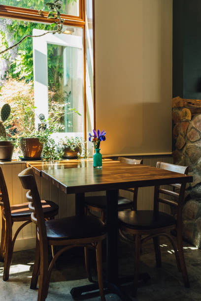 four top wooden table at restaurant with vase of purple flowers empty table at lunch restaurant by window 3610 stock pictures, royalty-free photos & images