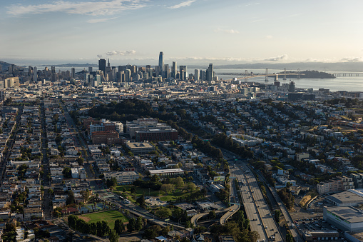 Aerial view of San Francisco, California, looking across the city from above Bernal Heights towards the downtown skyline and the Bay Bridge at sunrise on a summer morning.