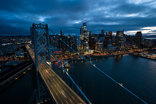 Aerial view of San Francisco at twilight on a summer evening, looking beyond the Bay Bridge towards Financial District skyscrapers and the Embarcadero.