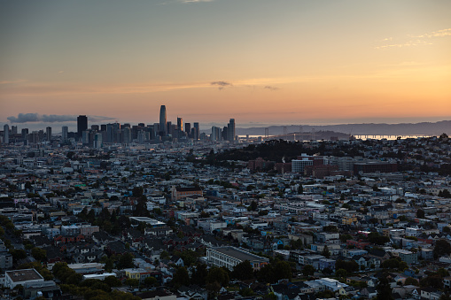 Aerial shot of San Francisco, California, looking across the city from above Bernal Heights towards the downtown skyline and the Bay Bridge at sunrise on a summer morning. This still image is part of a series; a time lapse video is also available.