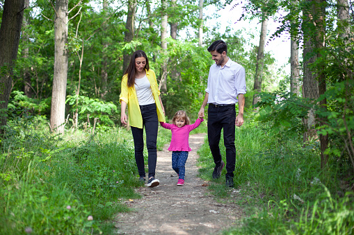Happy family enjoying their summer day walk in nature.