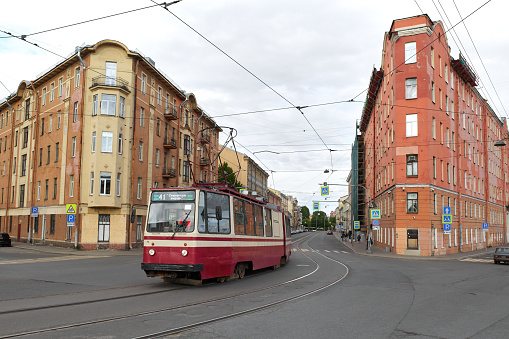 Cityscape of the street, old unusual residential buildings and tramway at the crossroads in the historical center of St. Petersburg, Russia. Unrecognizable people, cloudy gray day
