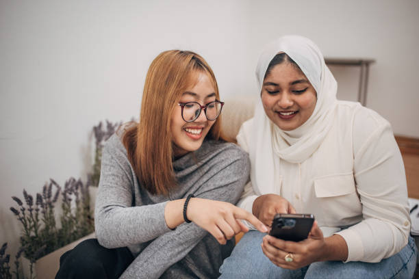 istock Modern female friends using phone 1500134343